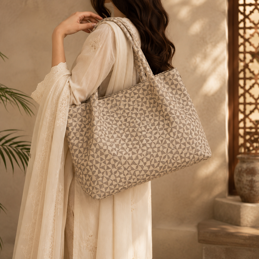 Woman holding a patterned tote bag in a warm, indoor setting